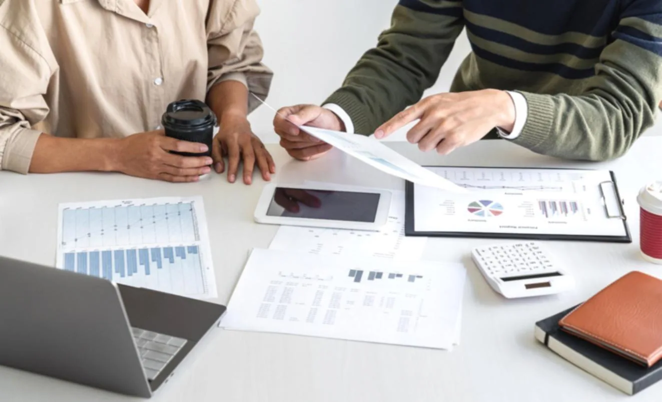 Budget planning session with notes and a financial overview on screen